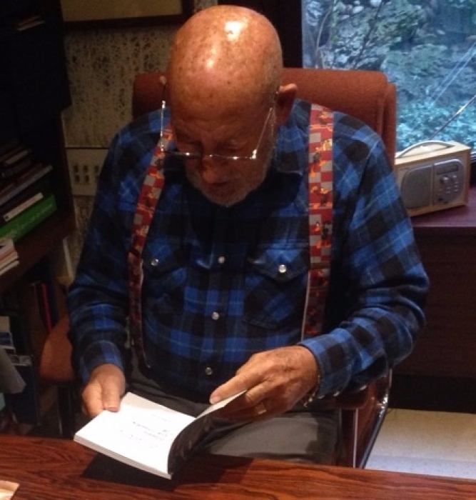 Sir Stirling Moss with his copy of our book  " All things Automobilia " photo shows Sir Stirling reading the book ALL PROFIT GOES TO CHARITY 